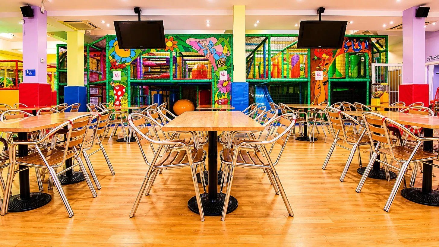 Café seating with the play frame behind at N20 KidsClub